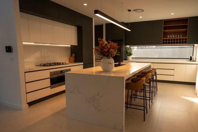 Modern kitchen with island and vibrant flower arrangement.