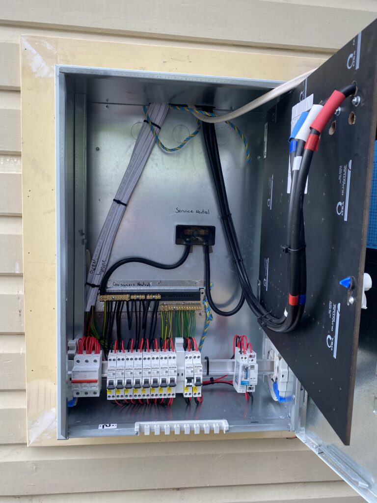 Open electrical service panel with wiring and breakers.