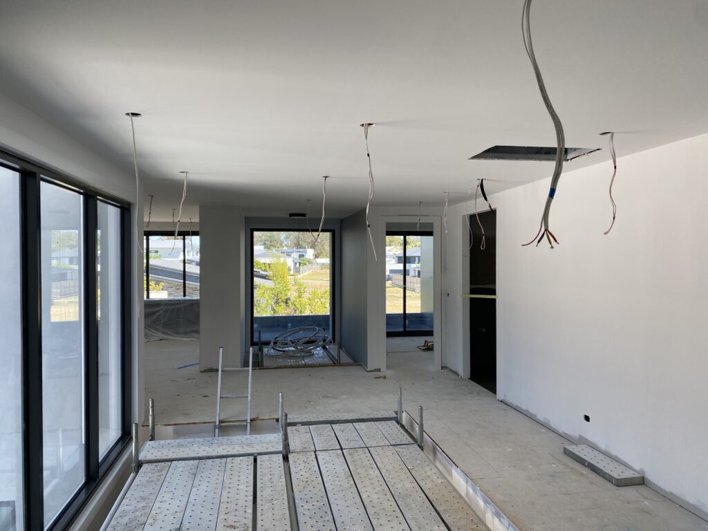 Under-construction interior with exposed wiring and scaffolding