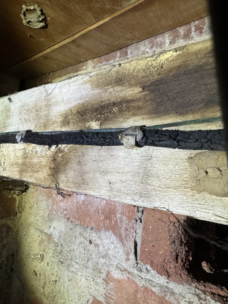Dark wood beam in a brick wall space.