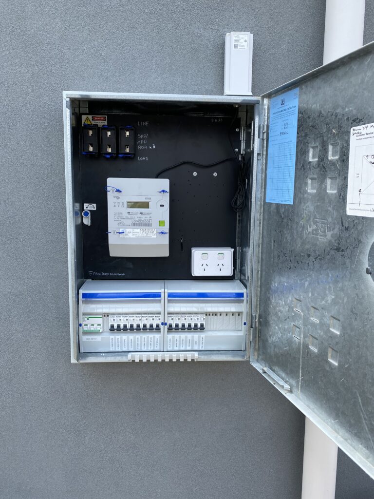 Electrical meter and circuit breaker panel outdoors.