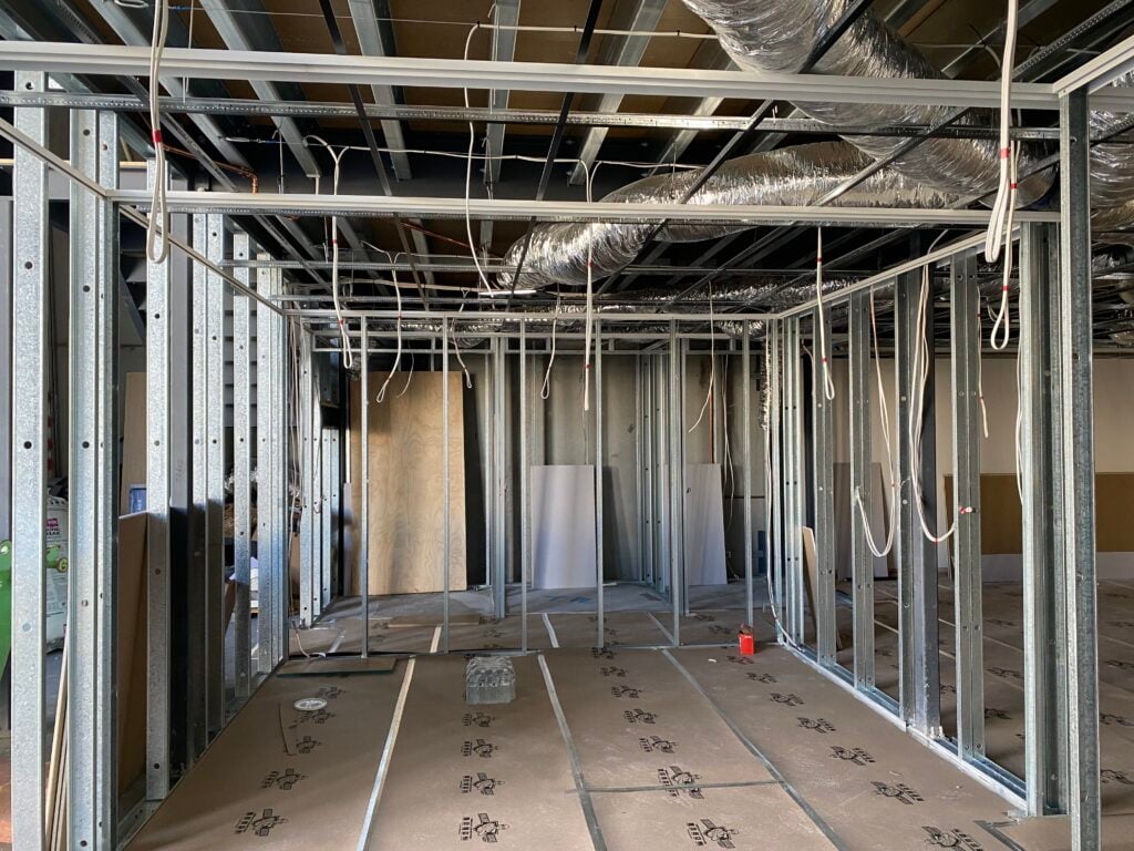 Interior construction site with metal framing and wires.