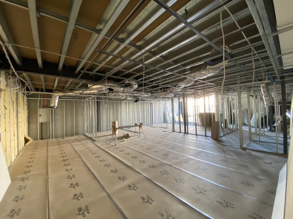 Empty room with exposed framing and flooring work