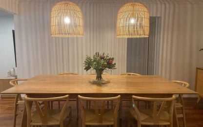 Stylish dining room with wooden table and pendant lights.