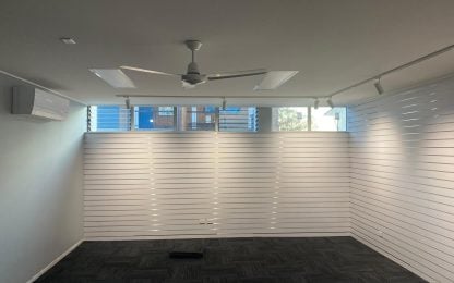 Bright, empty office space with ceiling fan.