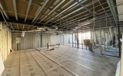 Empty room with exposed framing and flooring work