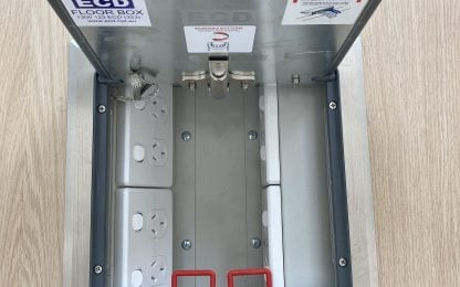 Open floor box with electrical sockets visible.